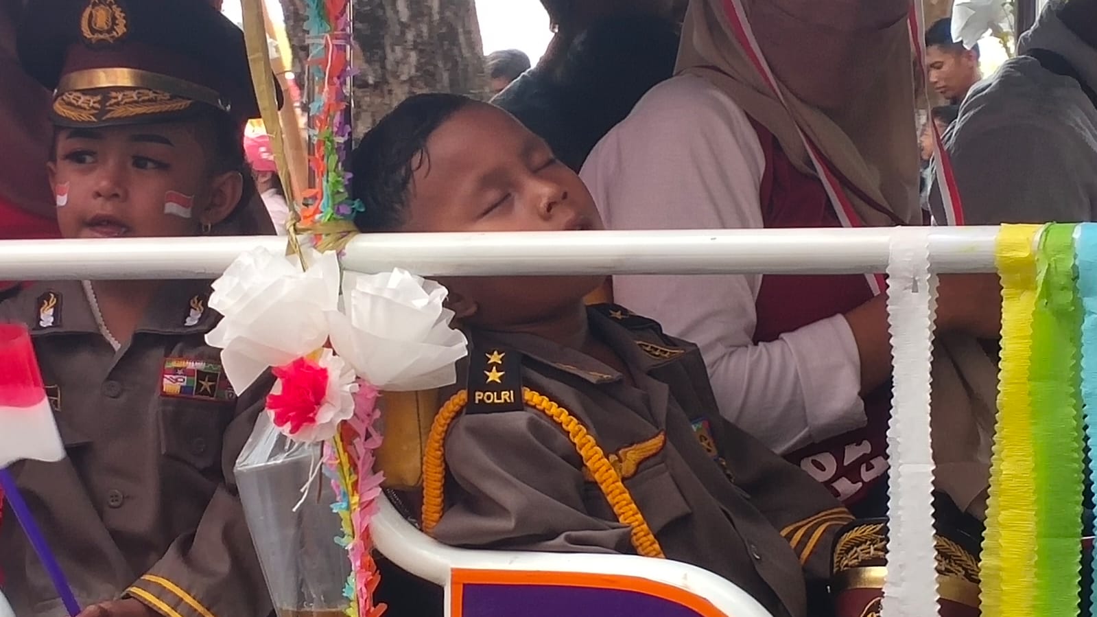 Bocah yang tidur saat ikuti karnaval pada Senin (21/8/2023)